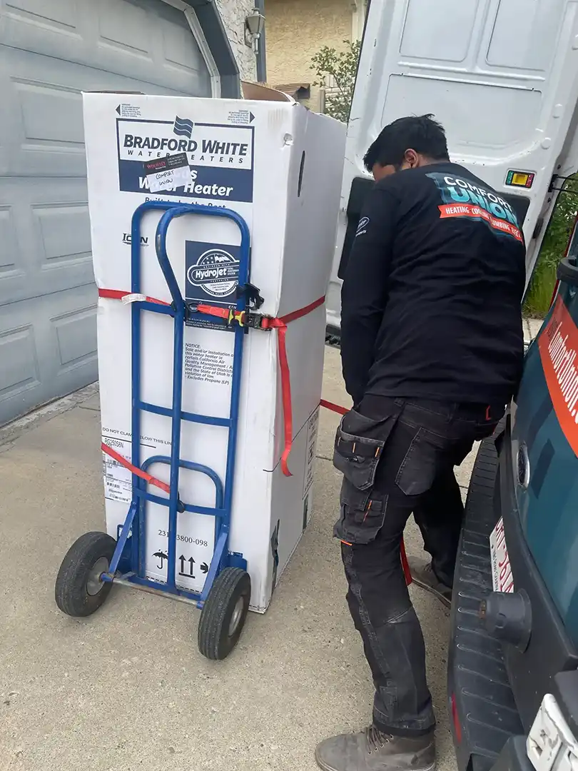 Comfort Union technician delivering and unloading a Bradford White gas water heater